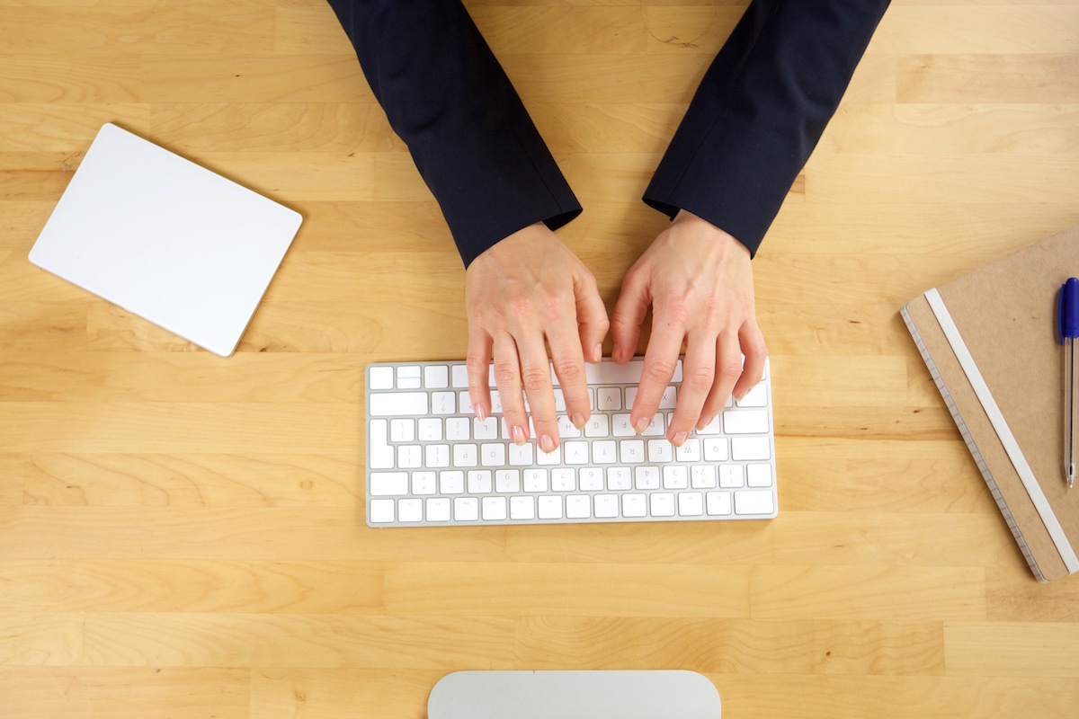 Image from above of hands typing on keyboard Image from above of hands typing on keyboard
